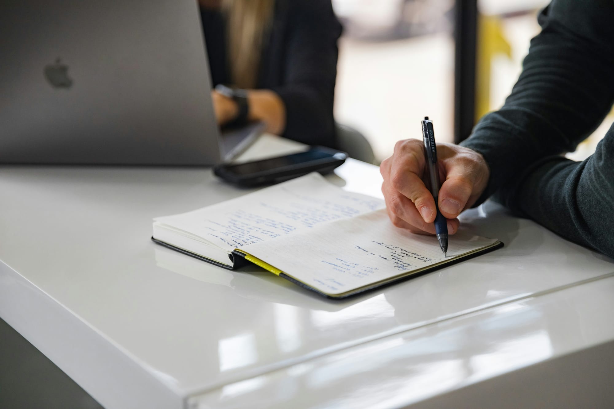 man noting down the benefits of marketing workflow software