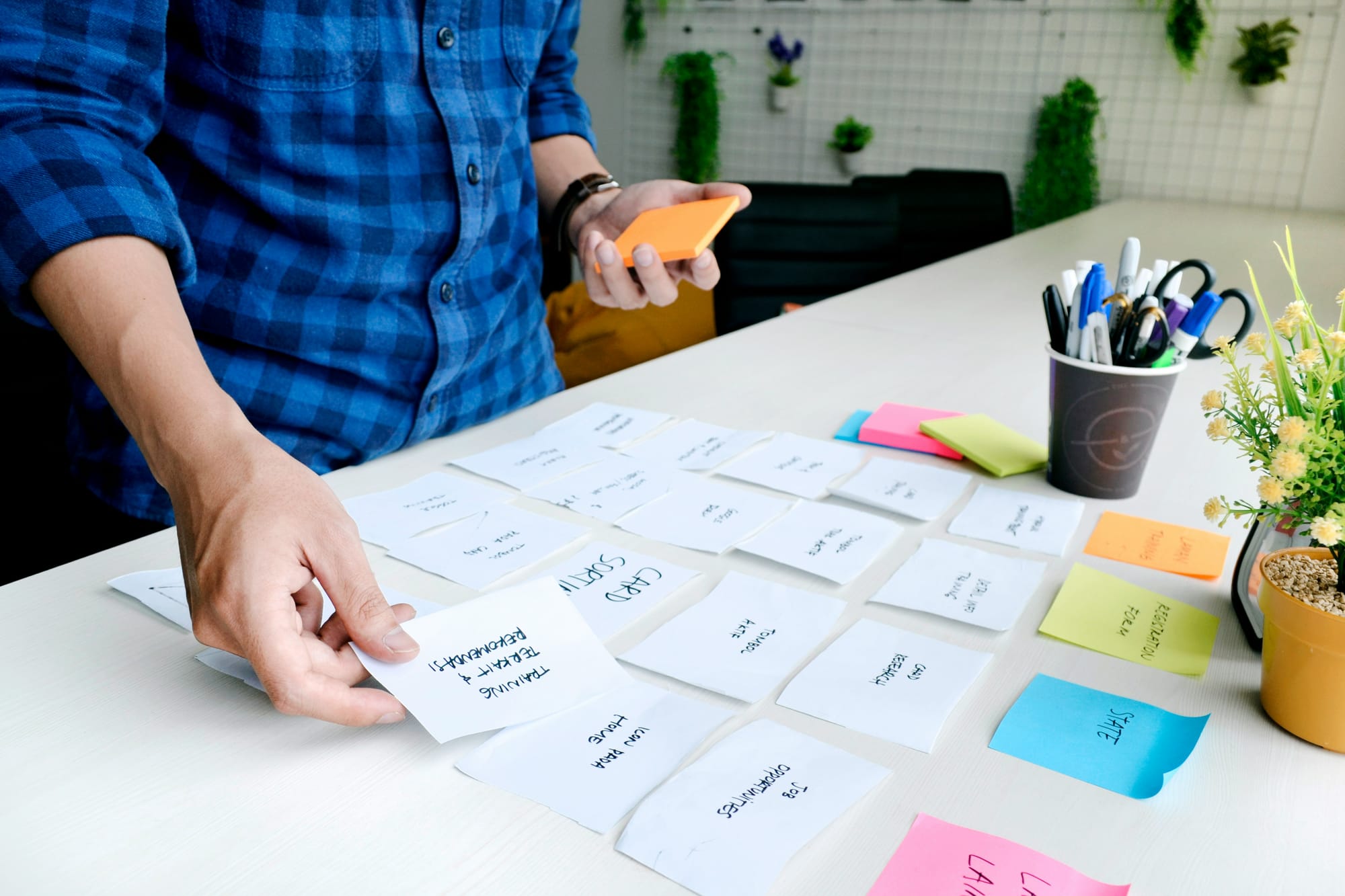 man arranging sticky notes according to priority - content marketing workflows
